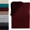 A stack of folded blankets in various colors next to a folded burgundy blanket. Produktbild-Vorschau