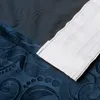 A close-up view of a dark blue fabric with a raised floral pattern, partially covered by a white fabric with a striped texture. Produktbild-Vorschau