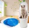 A cat is sitting in a toilet training system, with blue litter box inserts in the foreground. Produktbild-Vorschau