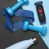 A flat lay of fitness equipment including dumbbells, a resistance band, a water bottle, and a fitness tracker. Produktbild-Vorschau