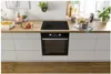A kitchen counter with a built-in oven and stovetop, along with some kitchenware and plants. Produktbild-Vorschau