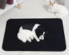 A black training pad with a stuffed dog on it, placed on a floor. A stuffed cat is in the background. Náhľad obrázku produktu