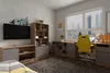 A modern bedroom or home office setup with a desk, chair, and entertainment unit. Náhľad obrázku produktu