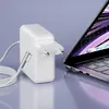 A white laptop charger and cable are placed next to an open laptop. Produktbild-Vorschau