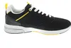 A side view of a black sneaker with yellow and white accents. Voir les images du produit