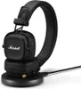 A black Marshall Major IV wireless Bluetooth headset is shown on a white background, resting on its charging base. Voir les images du produit