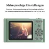 The back of a green digital camera is shown, displaying a photo of a woman sitting outdoors with the sun setting behind her. Text above the camera describes multilingual settings. Produktbild-Vorschau