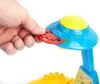A hand is inserting a red disc into a blue and yellow UFO-shaped toy projector. Náhľad obrázku produktu