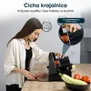 A woman is using a slicer in the kitchen, with vegetables and sliced meat on the counter. Podgląd zdjęcia produktu