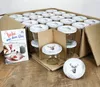 A box of glass jars with lids, along with a recipe booklet, is displayed on a wooden surface. Podgląd zdjęcia produktu