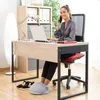 A woman is working at a desk with a laptop and talking on the phone, with her feet in a heated foot warmer. Produktbild-Vorschau