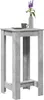 A tall, narrow bar table with a concrete-like finish, topped with a small gray cup and a vase of purple flowers. Produktbild-Vorschau