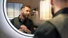 A man is looking in the mirror and adjusting his beard. Náhled obrázku produktu
