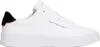 A white Tommy Hilfiger sneaker is shown from the side against a white background. Voir les images du produit