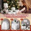 A woman is arranging illuminated Christmas gift boxes in front of a Christmas tree. Anteprima dell’immagine prodotto
