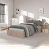 A bedroom scene with a bed, rug, and furniture, bathed in sunlight. Náhled obrázku produktu