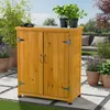 A wooden storage cabinet on a patio with plants. Produktbild-Vorschau