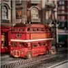 A detailed model of a red London double-decker bus is displayed on a street scene with miniature buildings and a lamppost. Anteprima dell’immagine prodotto