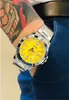 A person wearing a watch and blue pants. Voir les images du produit