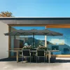 An outdoor dining set with a large umbrella in front of a modern house with large windows. Produktbild-Vorschau
