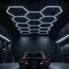 A black car parked in a modern, dark garage with hexagonal LED ceiling lights. Náhled obrázku produktu