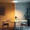 A split image showing a room with a table and chairs, with different lighting conditions. Produktbild-Vorschau