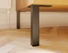 Close-up of black furniture legs attached to a wooden cabinet, resting on a wooden floor. Produktbild-Vorschau