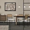 A dining room setting with chairs around a table, featuring a painting on the wall and a cabinet. Náhled obrázku produktu