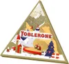 A triangular advent calendar shaped like a mountain scene with houses and a ski lift. Produktbild-Vorschau