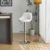A white bar stool is shown in a room with a wooden floor, a dark wood counter, and a potted plant. Náhľad obrázku produktu