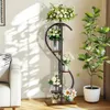 A living room scene with a sofa, a plant stand with flowers, and a large potted plant. Anteprima dell’immagine prodotto