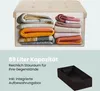 A storage ottoman filled with folded blankets, with text and an empty storage box below. Produktbild-Vorschau