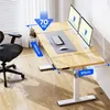 A standing desk with dual monitors, a keyboard, and a mouse, set up in a home office environment with a chair visible. Podgląd zdjęcia produktu