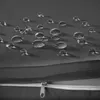 Close-up of water droplets on a gray fabric surface, with a zipper visible in the foreground. Náhled obrázku produktu