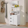 A white wooden cabinet with drawers and a door, decorated with a framed picture, flowers, and a candle. Produktbild-Vorschau