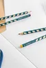 Several pencils are laid out on an open notebook. Anteprima dell’immagine prodotto