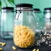A close-up shot of a glass jar filled with fusilli pasta, with other empty jars in the background. Produktbild-Vorschau