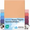 A stack of folded fitted sheets in various colors, with the main product in a peach color prominently displayed. Produktbild-Vorschau