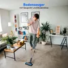 A man is vacuuming a living room floor with a cordless vacuum cleaner. Produktbild-Vorschau