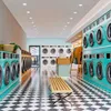 Interior of a modern laundromat with rows of washing machines and dryers. Voir les images du produit