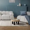 A living room scene with a white sofa, a coffee table, and a blue wall. Náhled obrázku produktu