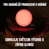 A bedside lamp simulating sunrise and sunset is shown on a table next to books, with text overlays describing its features. Náhľad obrázku produktu