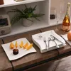 A table setting with plates, cutlery, fruit, and a bottle of champagne. Náhled obrázku produktu