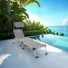 A lounge chair is placed on a patio next to an infinity pool with a tropical background. Náhled obrázku produktu