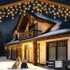 A house decorated with warm white icicle lights for Christmas, with a golden retriever and a child sitting in the snow in front of it. Náhľad obrázku produktu
