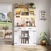 A white buffet cabinet with wooden accents, featuring glass doors, drawers, and storage compartments, placed in a well-lit room with a window overlooking a suburban scene. Podgląd zdjęcia produktu
