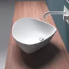 A white ceramic sink with a silver drain sits on a wooden countertop next to a white faucet. Produktbild-Vorschau