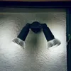 A black and silver outdoor wall light with two adjustable heads is mounted on a textured gray wall. Produktbild-Vorschau