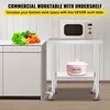 A commercial work table with a microwave and vegetables on top. Anteprima dell’immagine prodotto