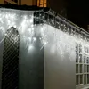 Icicle lights are hung along the roofline of a building, illuminating the exterior. Produktbild-Vorschau